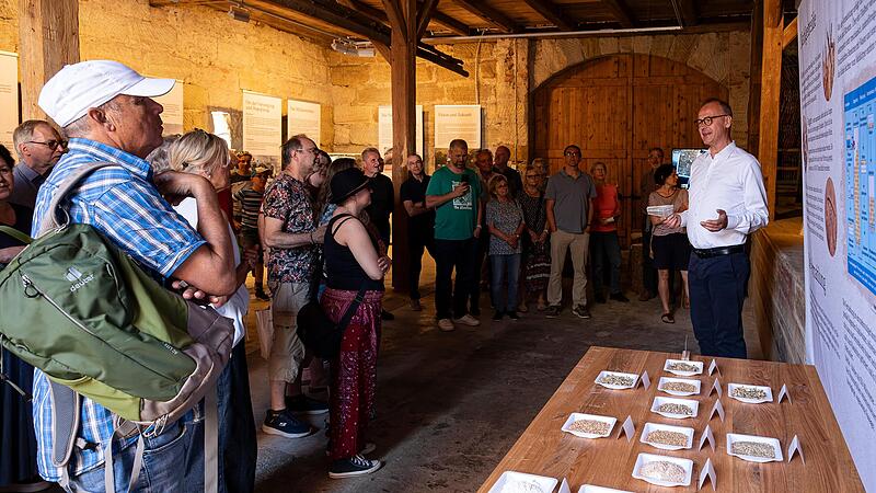 Andreas Hubmann (r.) stellt Besuchern das neu eröffnete Scheunenmuseum der Minderleinsmühle vor. Die Ausstellung zeigt historische Dokumente vom traditionellen Handwerksbetrieb zum modernen Bio-Unternehmen. Andreas Hubmann (r.) stellt Besuchern das neu eröffnete Scheunenmuseum der Minderleinsmühle vor. Die Ausstellung zeigt historische Dokumente vom traditionellen Handwerksbetrieb zum modernen Bio-Unternehmen.
