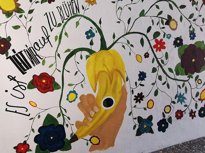 Kunstklasse der Eltmanner Realschule bemalt Fußgängerpassage zum Weltladen mit Fair-Trade-Symbolen