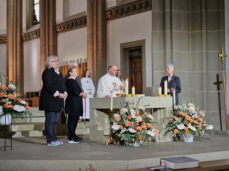 Pfarrer Greier am Altar in der Stadtpfarrkirche in Bad Kissingen mit Ministranten und Ehrenamtlichen.