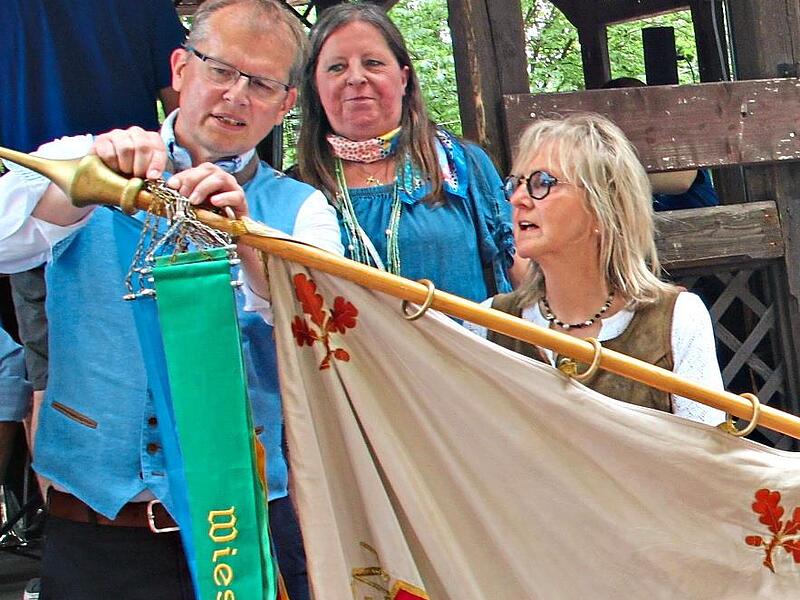 Der OB heftete das neue Fahnenband an die Wiesenfestfahne.