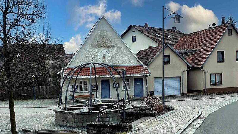 Ein hübscher Brunnen markiert die Ortsmitte von Weichtungen. Im Hintergrund die ehemalige Milch-Sammelstelle.