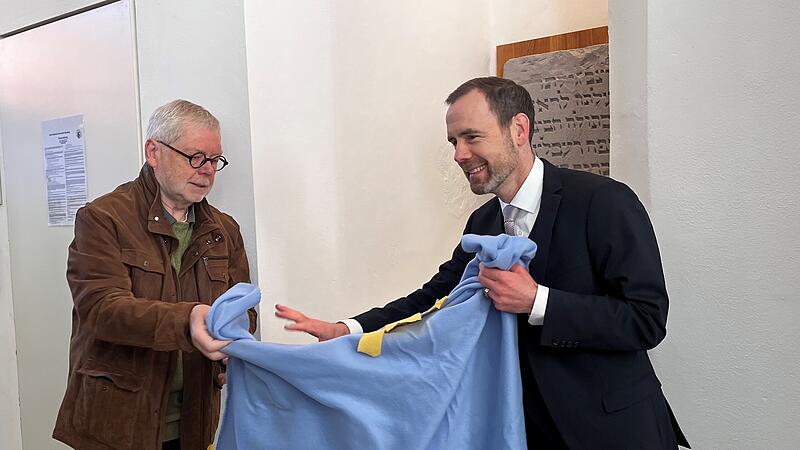 Prof. Godehard Ruppert (links) und Prof. Kai Fischbach (rechts) enth&uuml;llen den Nachdruck eines j&uuml;dischen Grabsteins aus dem Jahr 1400