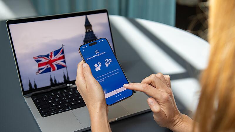 Eine Frau nutzt ein Handy, um einen ETA-Antrag zu stellen