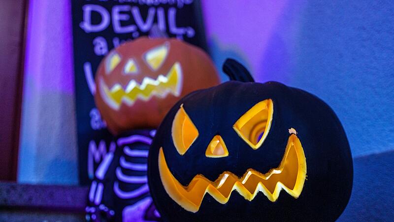 Illuminierte Kürbisse stehen im Vorgarten