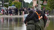 Ein Paar geht auf einer überfluteten Straße in Lugo. Nach den Unwettern und Überschwemmungen in Italien ist die Anzahl der Opfer weiter gestiegen.