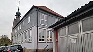 Das alte Schulgeb&auml;ude in Modlos und die Feuerwehrgarage daneben sollen abgerissen werden. An ihrer Stelle  soll ein modernes kombiniertes Geb&auml;ude f&uuml;r die Feuerwehr und Dorfgemeinschaft entstehen.