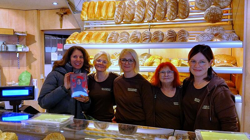 Heimatverbunden – in der Bäckerei Schauer in Wallenfels gibt es das neue Buch von Iris Mariposa (links) zu kaufen.