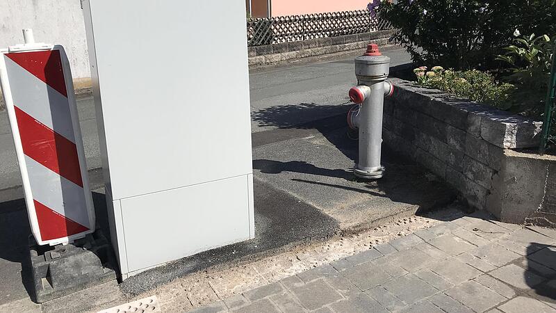 Der graue Kasten links behindert nicht nur die Ausfahrt von Vera Kraus, sondern auch den Anschluss von Schläuchen an den Hydranten auf der rechten Seite. Jetzt soll der Kasten versetzt werden in den Bereich am Rand des Grundstücks.
