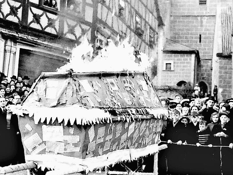 Emil Schurig hielt 1950 einen Nachruf auf die Zwangsbewirtschaftung durch Lebensmittelkarten. Die vielen Zuschauer sehen zu, wie der Sarg mit den Lebensmittelkarten in Flammen aufgeht.