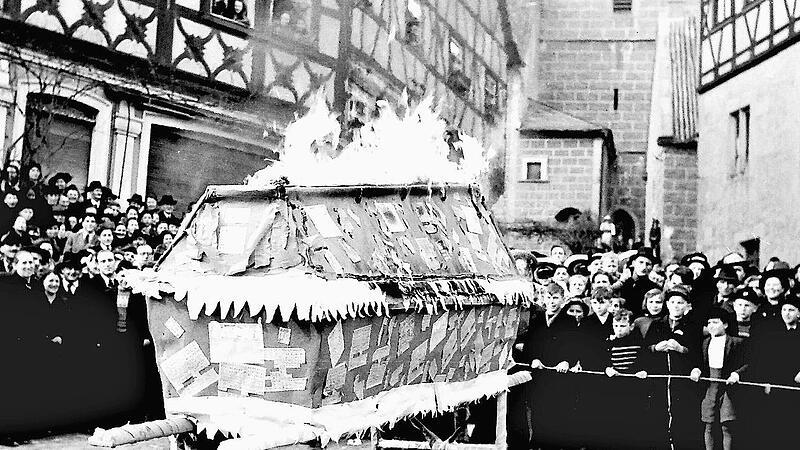 Emil Schurig hielt 1950 einen Nachruf auf die Zwangsbewirtschaftung durch Lebensmittelkarten. Die vielen Zuschauer sehen zu, wie der Sarg mit den Lebensmittelkarten in Flammen aufgeht.