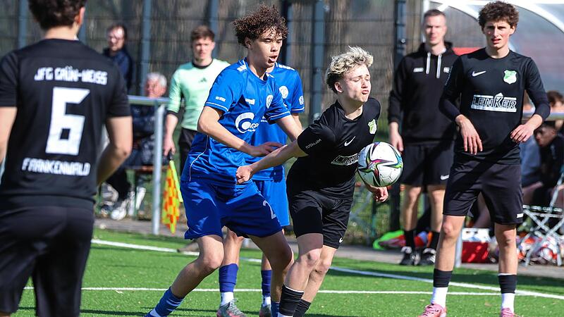 Unter Druck von W&uuml;rzburgs Joel Henderson (blau) nimmt Simon Pfadenhauer den Ball mit der Brust an.