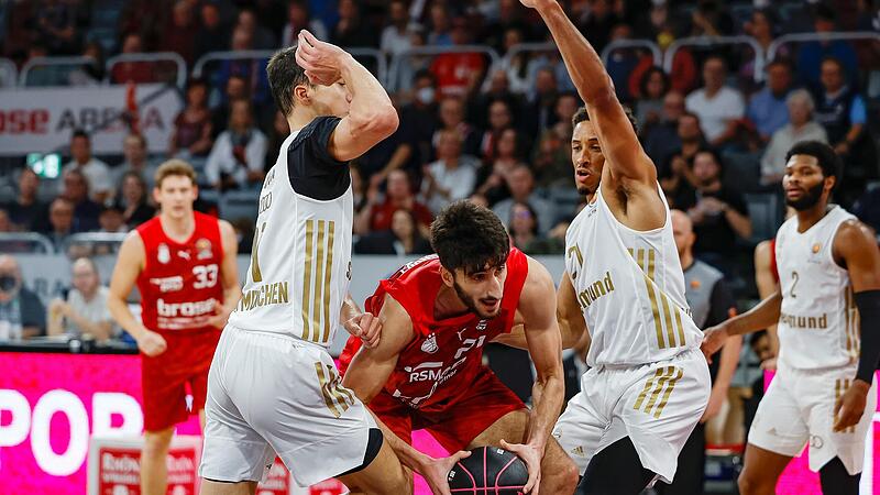 Die Münchner Vladimir Lucic (l.) und Augustine Rubit (r.) stellen sich im Pokalspiel, das die Bayern mit 85:68 klar für sich entschieden, Brose-Center Gabriel Chachashvili in den Weg.