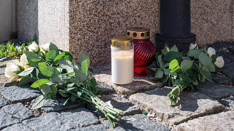 An der Straßenecke zur Zufahrtsstraße zum Kinder- und Jugendhilfezentrum in Wunsiedel, in dem eine Zehnjährige tot aufgefunden wurde, liegen Blumen und Grablichter auf dem Gehweg.