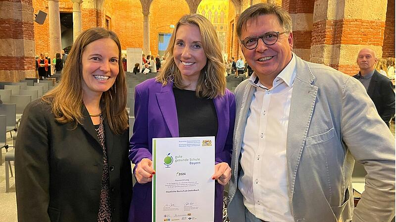 Kultusministerin Anna Stolz überreicht die Auszeichnung als "gute gesunde Schule" an Schulleiter Stefan Wolbert und Petra Fackelmann.