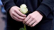 Mit einer weißen Rose in den Händen steht eine Schülerin vor dem Gelände der Paula-Fürst-Gemeinschaftsschule. Zwei Schülerinnen und eine Lehrerin der Schule waren unter den 86 Menschen, die im Jahr 2016 bei dem Attentat in Nizza starben.