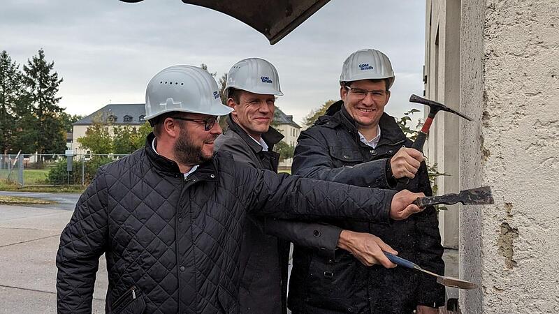 Mit H&auml;mmern und anderem Werkzeug kratzten Landrat Sebastian Straubel, Regiomed-Gesch&auml;ftsf&uuml;hrer Michael Musick und Oberb&uuml;rgermeister Dominik Sauerteig immerhin etwas Putz von der Wand. Die eigentlichen Abbrucharbeiten beginnen n&auml;chste Woche; der Ne...