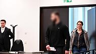 Das Foto zeigt den Angeklagten aus dem landkreis Erlangen-Höchstadt, wie er von Polizeibeamten in den Gerichtssaal geführt wird. Links am Bildrand sein Verteidiger Malte Magold aus Nürnberg.