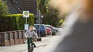 Junge f&auml;hrt mit dem Fahhrad auf einer Stra&szlig;e