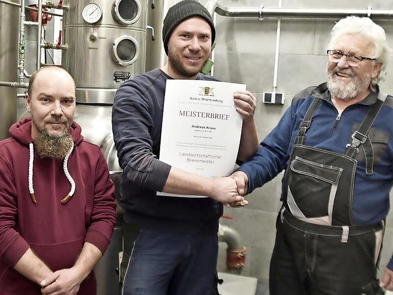 Hilmar Schmitt (rechts) gratuliert Andreas Kraus herzlich zu seiner mit Erfolg abgelegten Pr&uuml;fung zum Landwirtschaftlichen Brennmeister. Links steht Maik Pleyer aus Zeil, der sich in der Ausbildung zum Brennmeister befindet.
