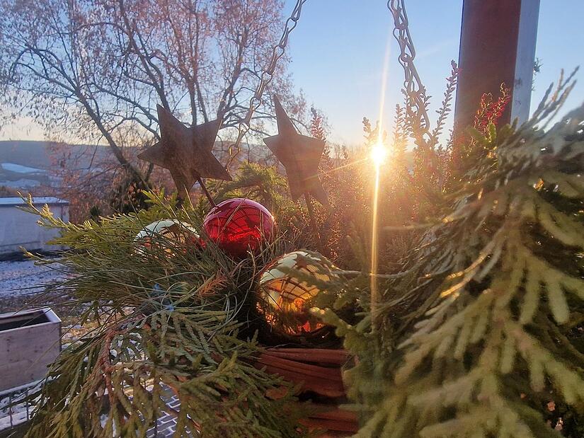 Für die Blumenampel im Eingangsbereich gibt es einige Kugeln, Zweige und zwei Metallsterne.