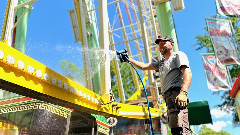Catalin hat Spa&szlig; bei der Wasserdusche f&uuml;r das Riesenrad kurz vor dem Beginn der Bergkirchweih in Erlangen.