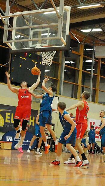 DJK-Kapit&auml;n Julian Roppelt (rot) packt beim Rebound gewohnt kr&auml;ftig zu.