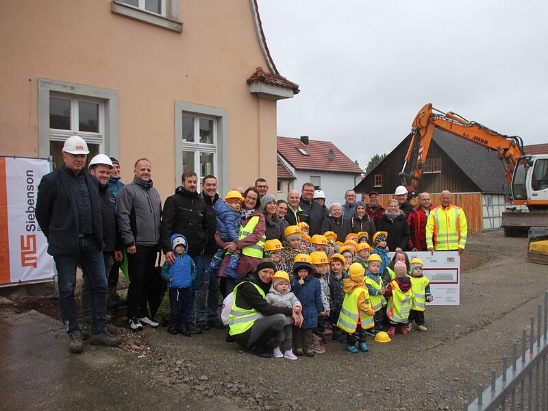 Verteter aus Politik, Verwaltung, Firmen und die Kindergartenkinder haben sich zum Spatenstich versammelt.