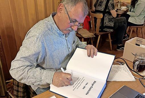 Autor G&uuml;nter B&ouml;hner schrieb pers&ouml;nliche Widmungen in die B&uuml;cher, die er am Vortragsabend verkaufte.