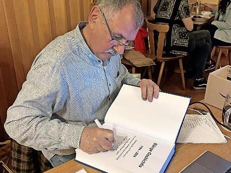 Autor G&uuml;nter B&ouml;hner schrieb pers&ouml;nliche Widmungen in die B&uuml;cher, die er am Vortragsabend verkaufte.