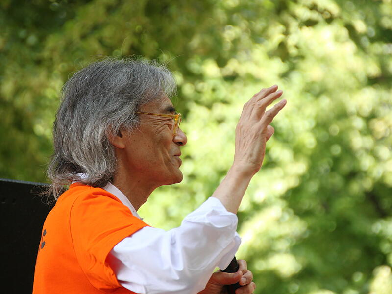 Kent Nagano dirigiert den Symphonic Mob 2023 mit einem Lächeln im Gesicht.