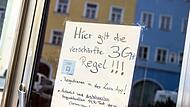 Auf einem Zettel an einer Scheibe von einem Café wird auf die Anwendung der verschärften „3G+ Regeln“.