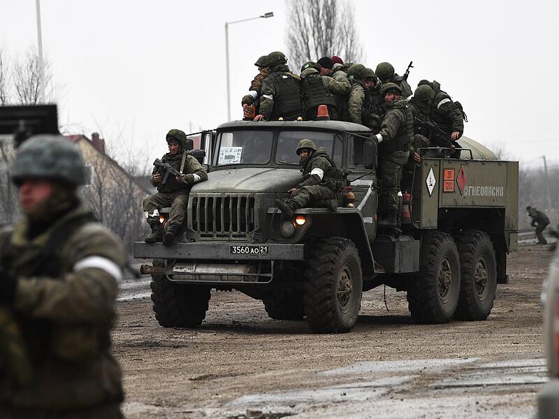 Russische Soldaten sitzen in der Stadt im Norden der Krim auf einem Militärlastwagen. Russland hat am Donnerstag einen umfassenden Angriff auf die Ukraine gestartet und Städte und Stützpunkte mit Luftangriffen oder Granaten beschossen.