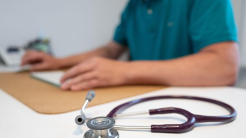 Stethoskop liegt neben einem Hausarzt im Sprechzimmer