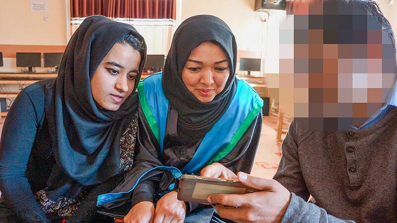 Patrick mit Frauen, die bis vor kurzem noch ein Zentrum des Bildungswerks &bdquo;Jesuit Worldwide Learning&ldquo; besuchen durften. Um den jungen Helfer vor Repressalien zu sch&uuml;tzen, haben wir sein Gesicht unkenntlich gemacht.