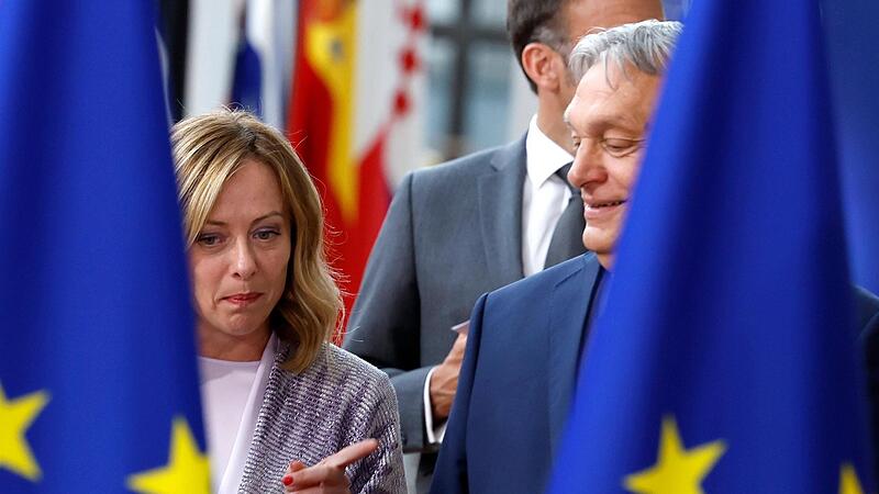 Ungarns Ministerpräsident Viktor Orban  spricht mit Italiens Ministerpräsidentin Giorgia Meloni vor einem Gruppenfoto auf einem EU-Gipfel in Brüssel.