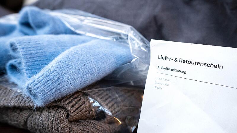 Liefer- und Retourenschein liegt neben online bestellter Kleidung