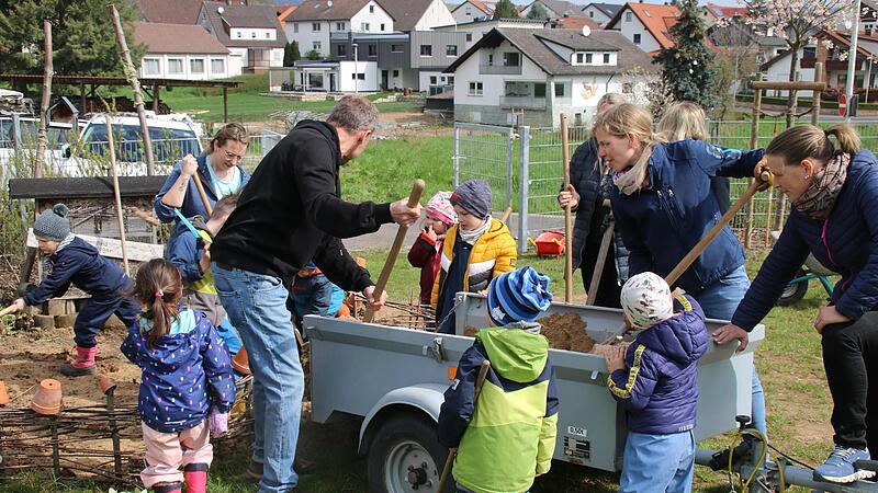 Eltern und Kinder schaufelten frische Erde in den Natur- und Insektenbereich. Eltern und Kinder schaufelten frische Erde in den Natur- und Insektenbereich.