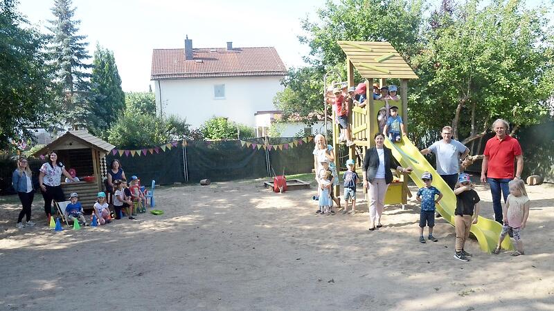Große Freude bei Personal und Kindern des Montessori-Kindergartens. Im Garten des Ausweichquartiers wurden neue Spielgeräte installiert. Links das Blockhaus, rechts der Spielturm mit Rutsche. Da kommt Bewegung auf. Davon konnten sich Bürgermeisterin Angela Hofmann (an der Rutsche links) sowie Georg Kreul und Ekkehard Roth überzeugen.