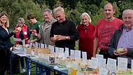 lle-Managerin Ulla Schmidt, OGV-Vorsitzende Irene Hüttner und Lukas Bandorf vom Naturpark Haßberge sowie Bürgermeister Karl-Heinz Kandler (rechts) begutachten mit weiteren Besuchern die vielen Apel- und Birnensorten.
