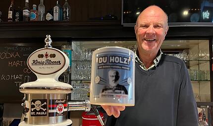 Freut sich auf den Live-Podcast in der &bdquo;K&ouml;pi&ldquo;: P&auml;chter Peter Kohlhepp mit der Du Holz-Tasse.