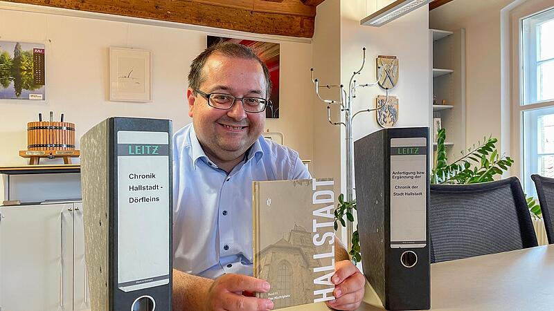 Zwei Aktenordner und 30 Jahre Vorlaufzeit: Hallstadts B&uuml;rgermeister Thomas S&ouml;der freut sich &uuml;ber den ersten Chronikband.