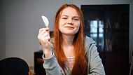 Anastasia hat eine Feder ihres Papageis mit nach Deutschland genommen.