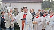 Pfarrer Michal Osak festigt Symbole auf die Osterkerze.