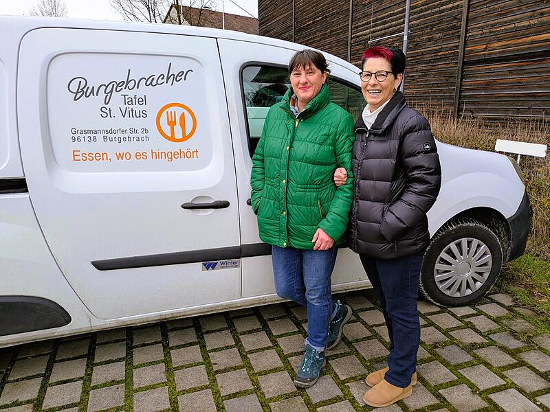 Die stellvertretende Leiterin Heidemarie Kaliski und Debrah Neser, Mitgr&uuml;nderin und Leiterin der Tafel Burgebrach, vor dem K&uuml;hlfahrzeug, das allm&auml;hlich schlapp macht.