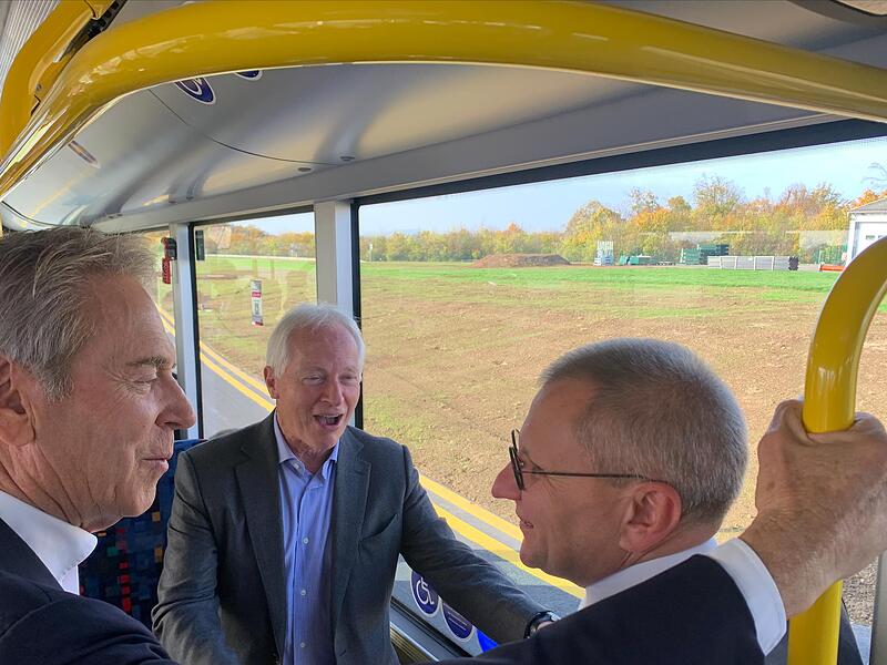 Die G&auml;ste der Er&ouml;ffnungsfeier unternahmen mit einem Bus eine Platz-Rundfahrt. Von links: die Unternehmer Michael Stoschek und Martin Kapp sowie Siegmar Schnabel von der IHK.