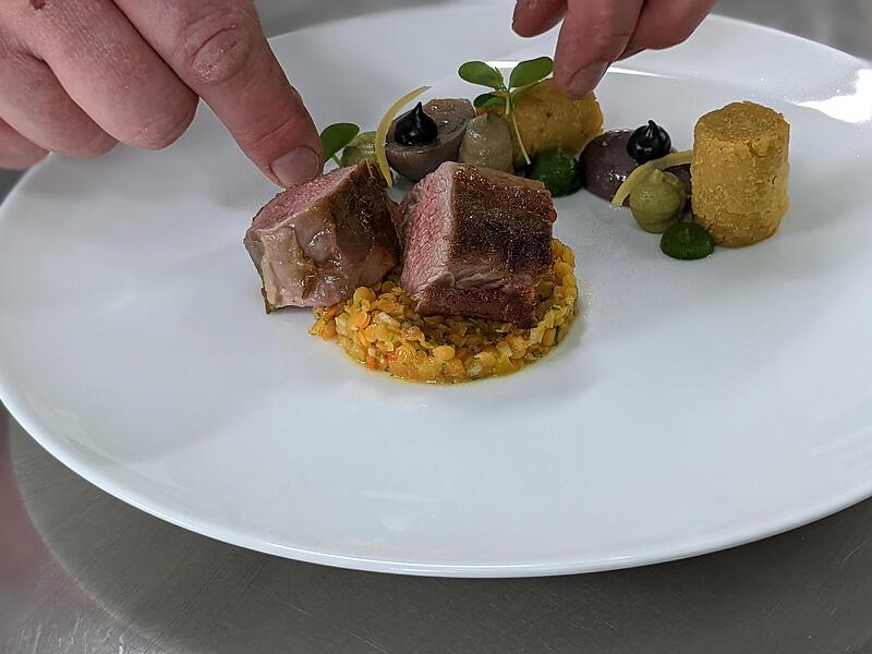 Das Lammfleisch wird zerschnitten und dazugelegt, am Ende kommt noch etwas Kresse dazu.