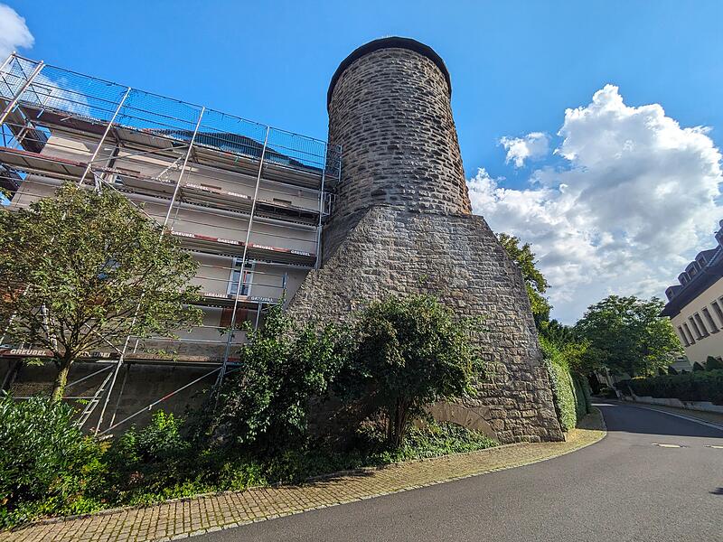 Im unteren Bereich des Turms wird der Höhenunterschied von der Straße zum Areal deutlich: Der Torbogen ist kaum zu sehen. Im unteren Bereich des Turms wird der Höhenunterschied von der Straße zum Areal deutlich: Der Torbogen ist kaum zu sehen.