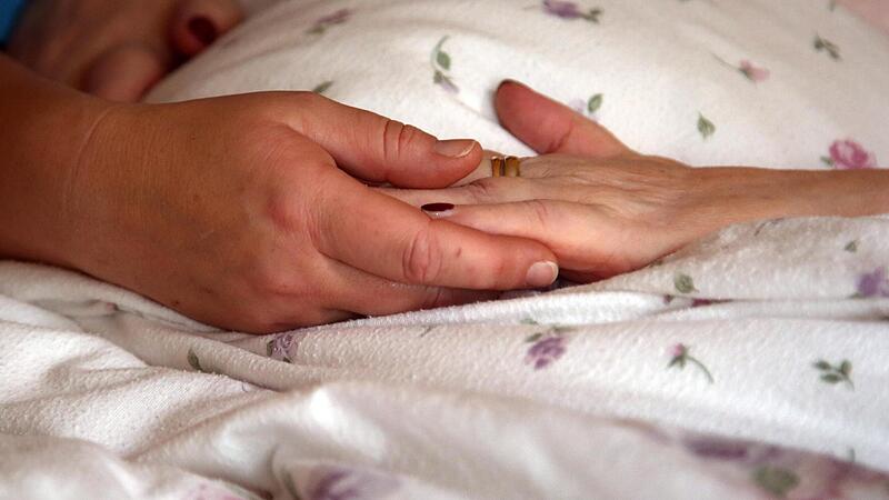 Die Hände einer Bewohnerin liegen in einem Hospiz auf einer Bettdecke.Forchheim & Fränkische Schweiz