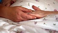 Die Hände einer Bewohnerin liegen in einem Hospiz auf einer Bettdecke.Forchheim & Fränkische Schweiz