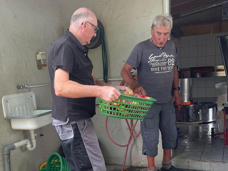 Heinz Rumpel (links) und Willi Hüttner vom Obst- und Gartenbauverein Neubrunn bereiten die Äpfel für die Kelter vor.